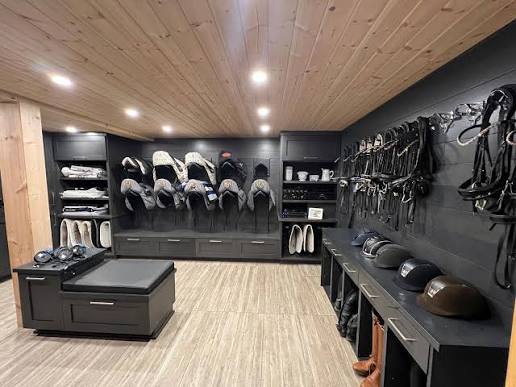 Modern tack room with built-in cabinetry and organized storage